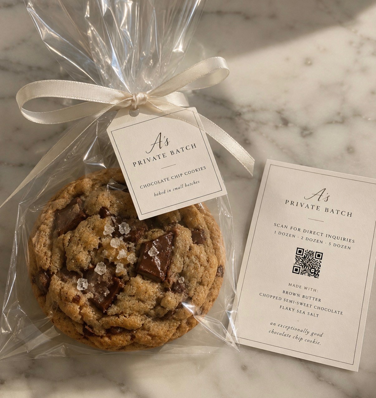 A's Private Batch chocolate chip cookie wrapped with an ivory ribbon and branded card